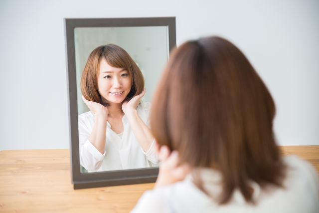 ヘアスタイルを気にする女性(笑顔)